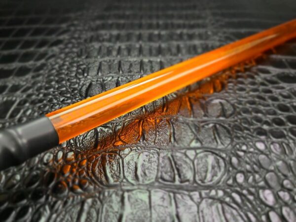 amber/orange acrylic rod against alligator faux leather