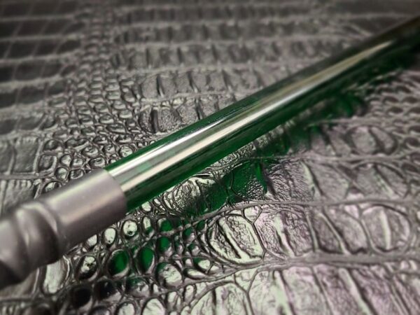 Green acrylic rod against alligator faux leather